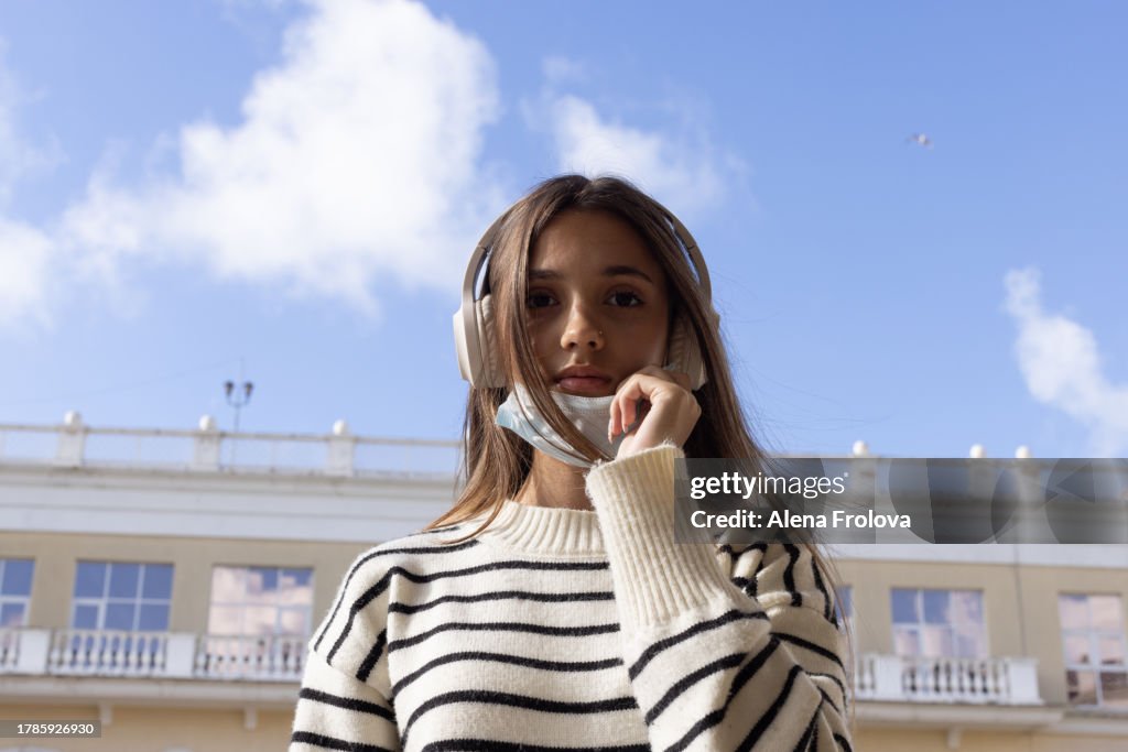 Portrait of beautiful young woman dressing mask