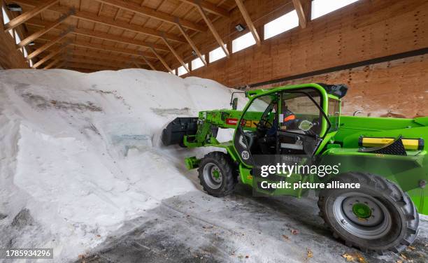 November 2023, Saxony, Chemnitz: A wheel loader picks up road salt in the salt hall of the highway maintenance depot in Chemnitz. Saxony's highway...