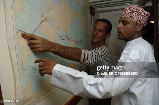 French explorer Patrice Franceschi, captain of the three-masted schooner ship La Boudeuse, shows an omani fisherman the route he followed around the...