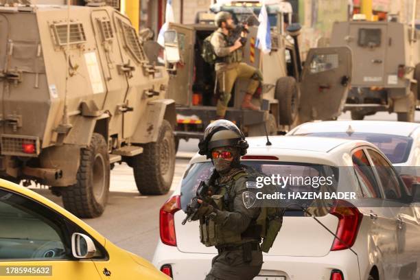 An Israeli security force officer takes position as they surround the area of a Palestinian home, believed to belong to one of the gunmen that...