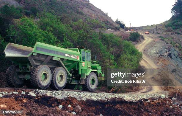 Local residents and Heavy Equipment Operators share a narrow dirt road while road repairs are being completed to California Highway 1 after large...