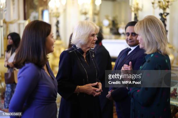 Queen Camilla speaks to Dame Joanna Lumley watched by Dr Linda Yueh as she hosts a reception at Buckingham Palace for winners of The Queen's...