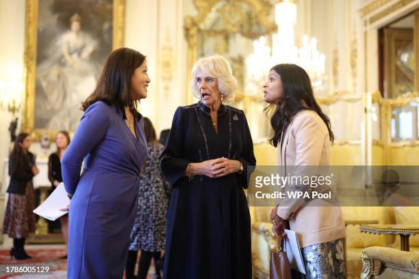 Queen Camilla speaks with Britain's Prime Minister wife Akshata Murty and Dr Linda Yueh as she hosts a reception at Buckingham Palace for winners of...