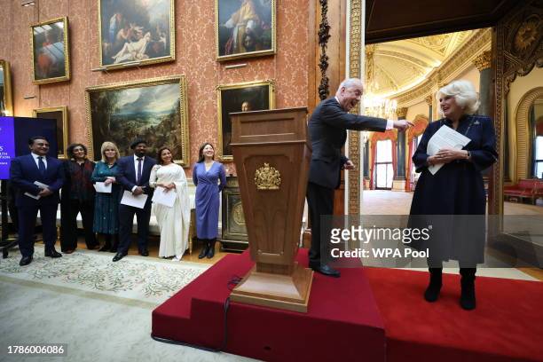 Queen Camilla speaks with Gyles Brandreth as Dr Linda Yueh and other guests listen, during a reception at Buckingham Palace for winners of The...