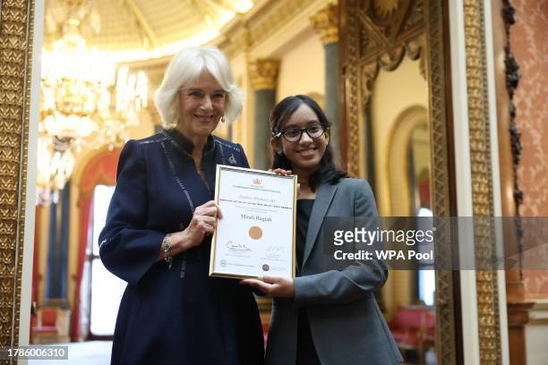 Queen Camilla poses with Mitali Ragtah, junior runner-up as she hosts a reception at Buckingham Palace for winners of The Queen's Commonwealth Essay...