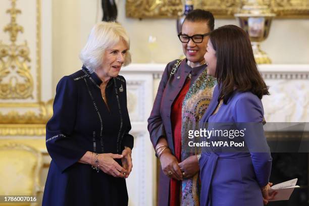 Queen Camilla speaks with Dr Linda Yueh as she hosts a reception at Buckingham Palace for winners of The Queen's Commonwealth Essay Competition 2023...