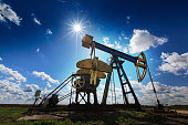An oil and gas well against a sunny sky