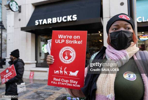Former employees and supporters join unionized Starbucks employees as they carry signs in support of a strike, outside of a Starbucks store in...