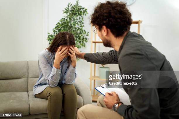 terapeuta que brinda apoyo psicológico a una mujer durante la sesión de terapia - psychiatrists couch fotografías e imágenes de stock