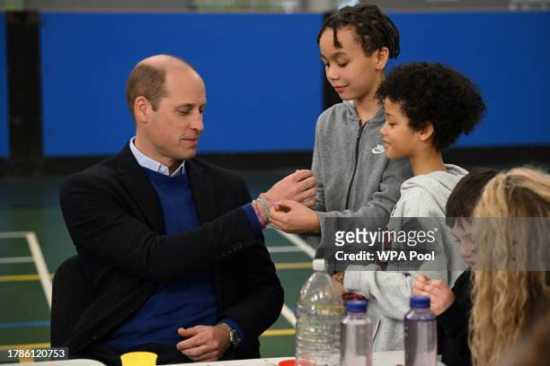 Britain's Prince William, Prince of Wales receives a friendship bracelet as he visits the Millennium Powerhouse, a multi-service youth hub which...