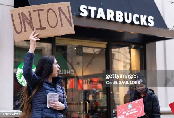 Steph Kronos , a pro-Union activist, joins Starbucks workers, former employees, and supporters in holding signs in support of a strike, outside of a...