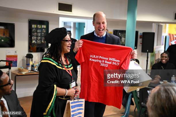 Britain's Prince William, Prince of Wales receives a t-shirt during a visit of the Millennium Powerhouse, a multi-service youth hub which works with...