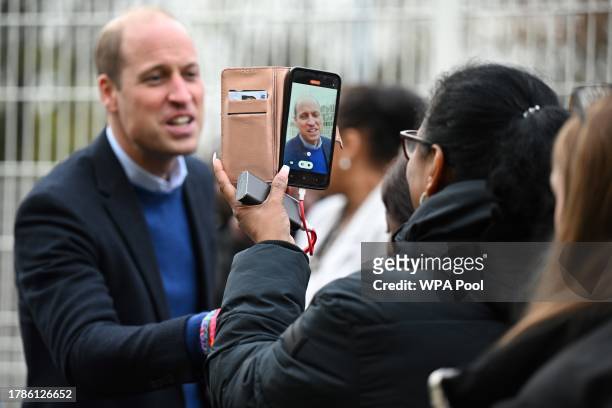 Britain's Prince William, Prince of Wales is filmed on a mobile phone as he meets with well-wishers during a visit of the Millennium Powerhouse, a...