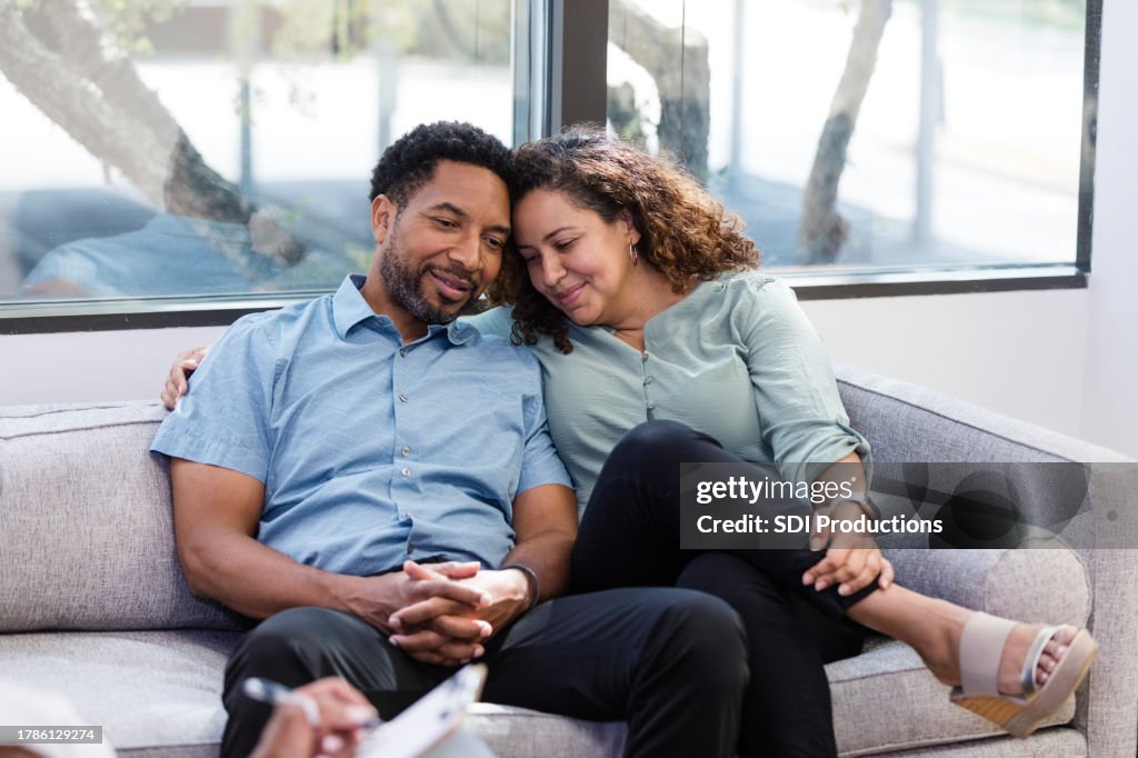 During therapy, happy couple touch heads and close eyes