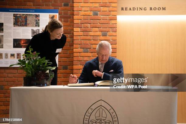 King Charles III signs a visitors book at a reception of faith leaders during a visit to the new Lambeth Palace Library to mark Inter Faith Week,...