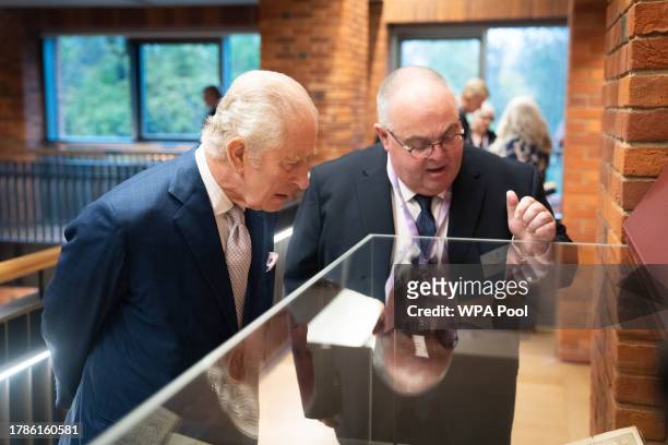 King Charles III looks at religious books during a reception of faith leaders during a visit to the new Lambeth Palace Library to mark Inter Faith...