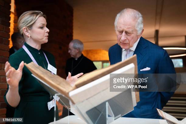 King Charles III looks at religious books during a reception of faith leaders during a visit to the new Lambeth Palace Library to mark Inter Faith...