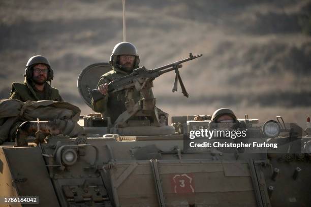Israeli soldiers stand ready in their armoured personnel carrier in the Golan Heights near the Israeli border with Lebanon on November 10, 2023 near...