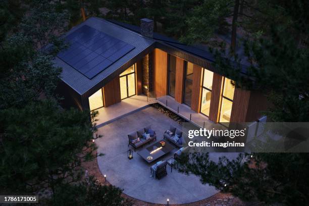 forest house with solar panels and wall battery for energy storage - gerador imagens e fotografias de stock
