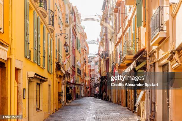 narrow street with shops and restaurant on a sunny morning in the old town, monaco-ville, monaco - montecarlo fotografías e imágenes de stock