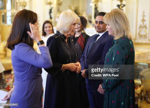 Queen Camilla speaks to Dame Joanna Lumley watched by Dr Linda Yueh as she hosts a reception at Buckingham Palace for winners of The Queen's...