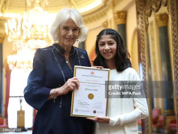 Queen Camilla poses with Shreeya Sahi, junior winner as she hosts a reception at Buckingham Palace for winners of The Queen's Commonwealth Essay...
