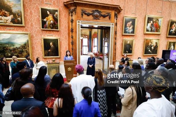 Queen Camilla listens as Dr Linda Yueh speaks as she hosts a reception at Buckingham Palace for winners of The Queen's Commonwealth Essay Competition...