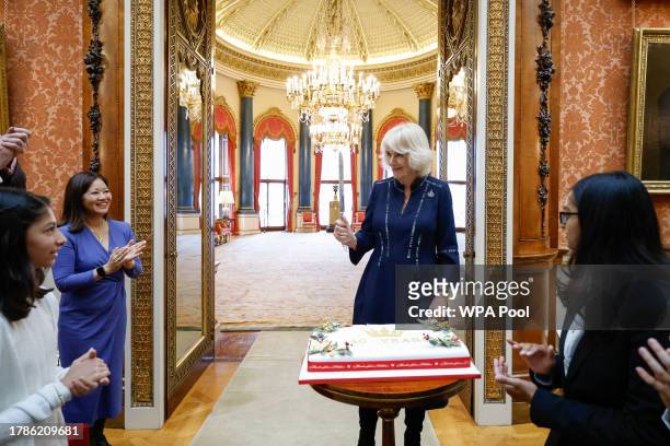 Queen Camilla speaks as Dr Linda Yueh as she hosts a reception at Buckingham Palace for winners of The Queen's Commonwealth Essay Competition 2023...