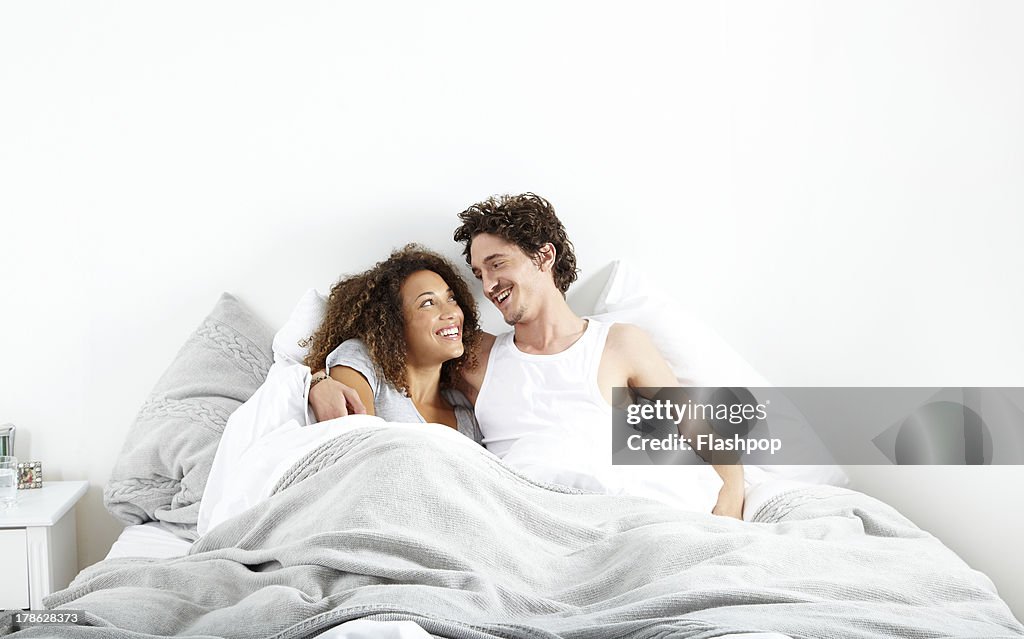 Couple sitting up in bed together