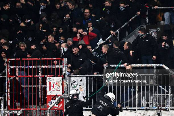 Hannover 96 fans clash with police during the Second Bundesliga match between FC St. Pauli and Hannover 96 at Millerntor Stadium on November 10, 2023...