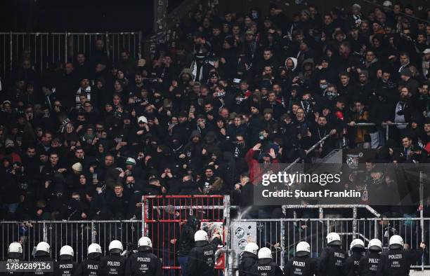 Hannover 96 fans clash with police during the Second Bundesliga match between FC St. Pauli and Hannover 96 at Millerntor Stadium on November 10, 2023...