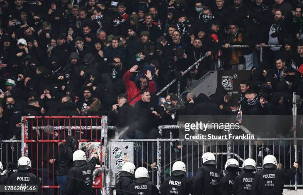 Hannover 96 fans clash with police during the Second Bundesliga match between FC St. Pauli and Hannover 96 at Millerntor Stadium on November 10, 2023...