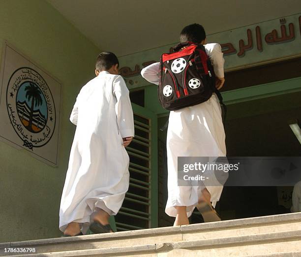 Saudi schoolboys enter their school as Saudi schools start the first day in the eastern city of Dammam 10 September 2005. Five Al-Qaeda suspects on a...