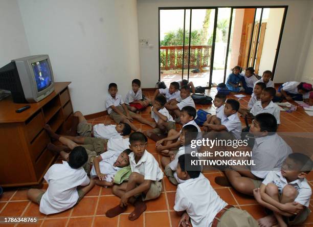 Thai students watch a television program in their hotel room which serves as a class after tsunamis destroyed their school in Phuket, southern...