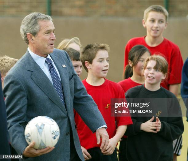 President George W. Bush plays with junior high school students at Sedgefield Community College in Sedgefield, England, 21 November 2003 during a...