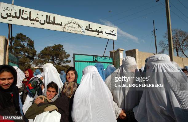Photo of Afghan schoolgirls and their mothers wearing the burka taken 30 January 2002 after school in Mazar-e-Sharif. AFP PHOTO ERIC FEFERBERG