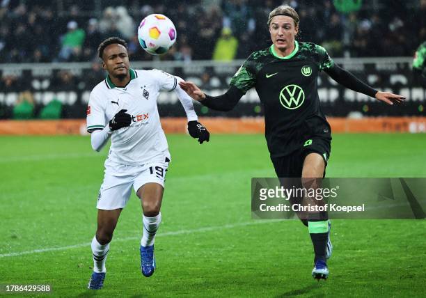 Nathan Ngoumou of Borussia Moenchengladbach and Sebastiaan Bornauw of VfL Wolfsburg battle for possession during the Bundesliga match between...