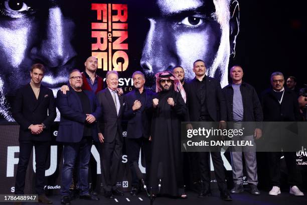 Britain's Tyson Fury and Ukraine's Oleksandr Usyk pose for poictures with members of their team, members of the organisation and US actor Sylvester...
