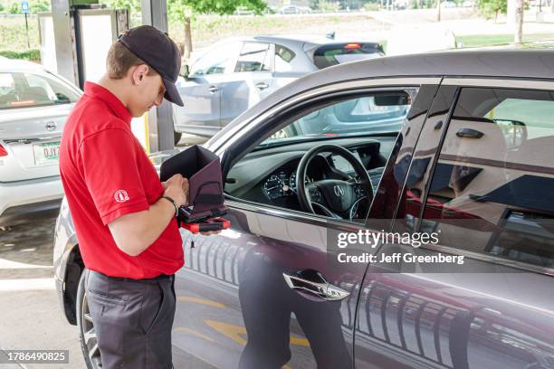 Macon, Georgia, Chick-fil-A fast food restaurant, drive thru in vehicles man employee using tablet to take order.