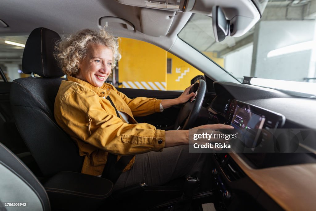 Mature woman leaving a garage with her car