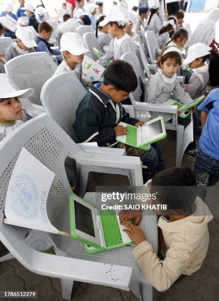 Palestinian schoolchildren inspect new laptops at a school in Rafah, in the southern Gaza Strip, on April 29, 2010. The UN agency for Palestinian...