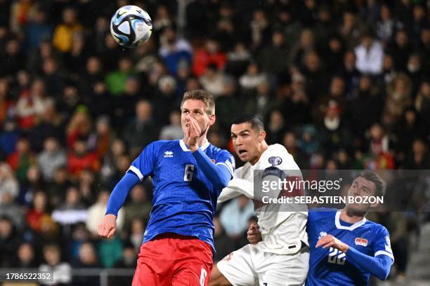 Liechtenstein's defender Andreas Malin, Portugal's forward Cristiano Ronaldo and Liechtenstein's defender Niklas Beck go for a header during the UEFA...
