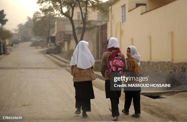 Afghan schoolgirls return to their homes from their closed school in Kabul on November 2, 2009. The Afghan government have ordered the closure of all...