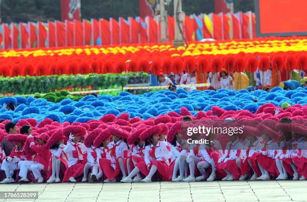 Chinese children dressed in costumes wait on Tiananmen Square for the National Day parade to start in Beijing on October 1, 2009. China celebrated 60...