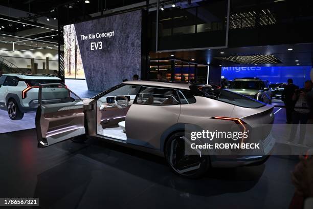 Visitors look at the Kia Concept EV4 during the Kia press conference at Automobility LA, the media preview day for the LA Auto Show, on November 16,...