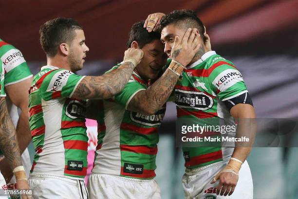 Nathan Merritt of the Rabbitohs celebrates with team mates Issac Luke and Adam Reynolds after scoring a try during the round 25 NRL match between the...