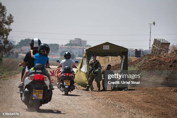 Israelis arrive to watch the 'Iron Dome' missile defense system as it is guarded by Israeli soldiers on August 30, 2013 in Tel Aviv, Israel. Tensions...