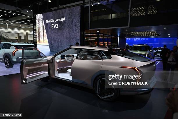 Visitors look at the Kia Concept EV4 during the Kia press conference at Automobility LA, the media preview day for the LA Auto Show, on November 16,...