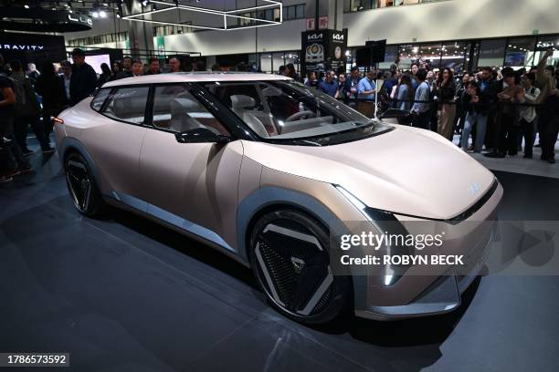 Visitors look at the Kia Concept EV4 during the Kia press conference at Automobility LA, the media preview day for the LA Auto Show, on November 16,...