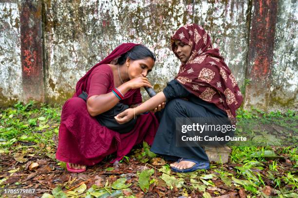 a nomadic gypsy healer from bangladesh blows through her horn to cure a patient - poor performance stock pictures, royalty-free photos & images